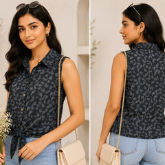 Woman wearing a sleeveless patterned top with denim shorts, holding flowers and a handbag.