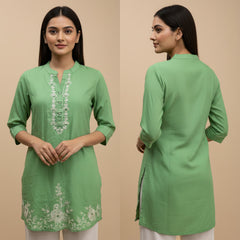 Green embroidered kurta worn by a model on a beige background