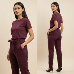 Woman wearing a maroon outfit with a belt on a beige background