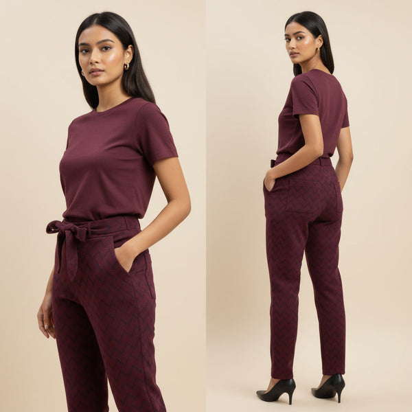 Woman wearing a maroon outfit with a belt on a beige background