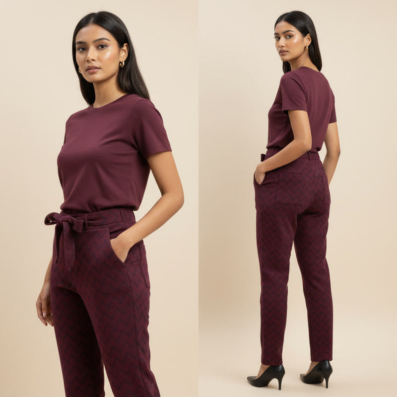 Woman wearing a maroon outfit with a belt on a beige background