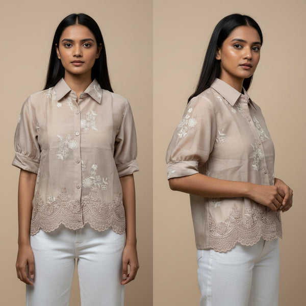 Woman wearing a beige blouse with floral embroidery and lace details on a beige background