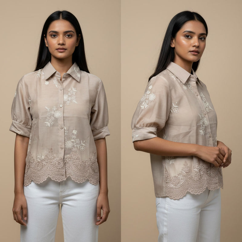 Woman wearing a beige blouse with floral embroidery and lace details on a beige background