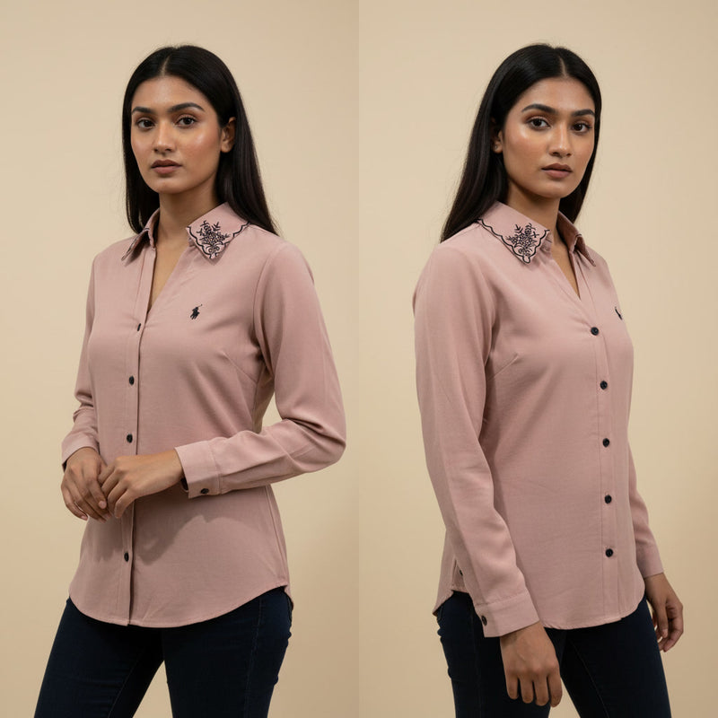 Woman wearing a pink shirt with decorative collar details on a beige background