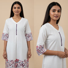 Two women wearing white kurta with floral patterns on a beige background