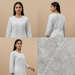 Woman wearing a white embroidered dress with close-up of fabric texture on a beige background