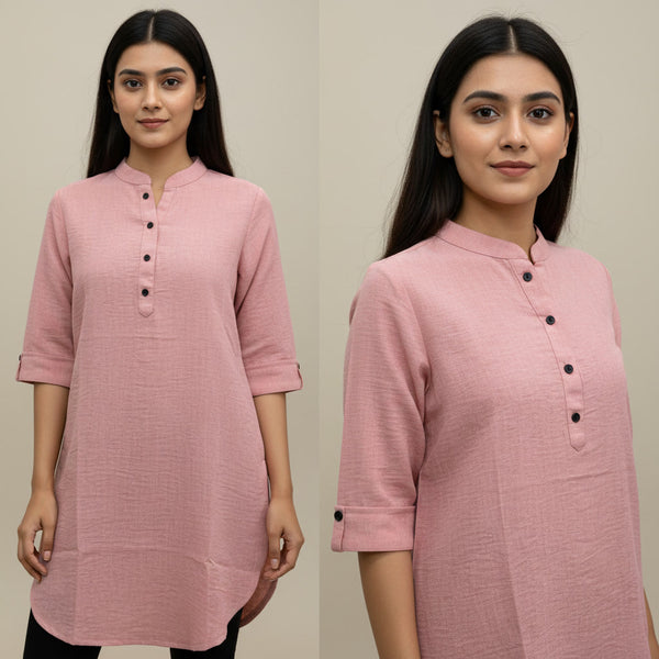 Woman wearing a pink kurta with black buttons on a plain background