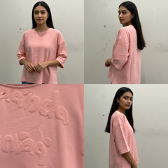 Woman wearing a pink outfit with close-up details on a plain background