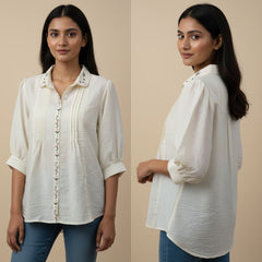 Woman wearing a white blouse with rolled-up sleeves on a beige background