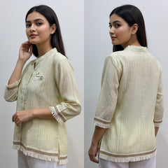 Woman wearing a light green traditional outfit with white pants, shown from front and back on a plain background.