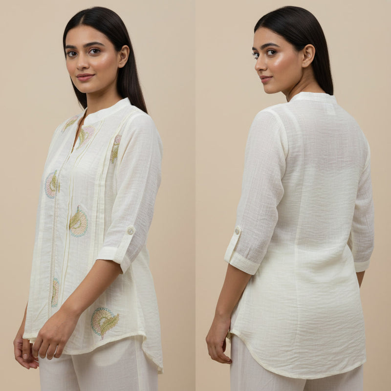 Woman wearing a white embroidered outfit on a beige background