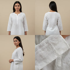 White kurta with lace details worn by a model on a beige background