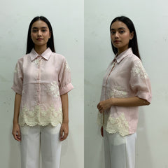 Two images of a woman wearing a pink blouse with lace details against a plain background.