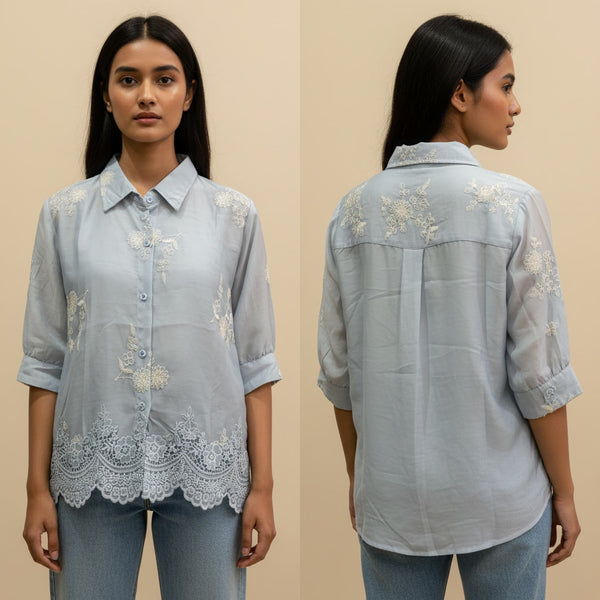Woman wearing a light blue embroidered shirt from front and back views on a beige background