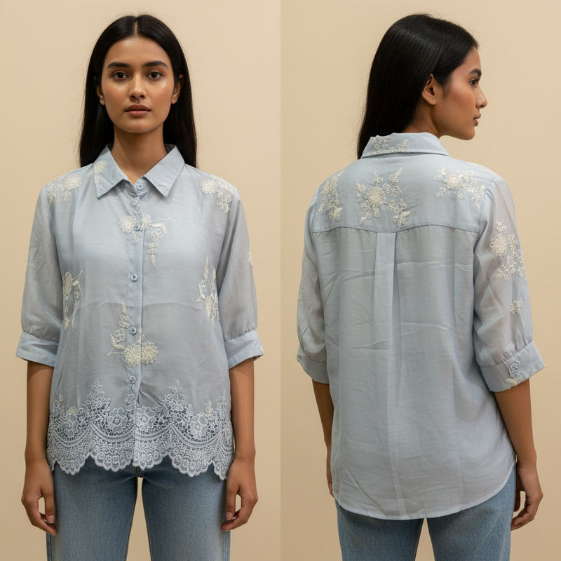 Woman wearing a light blue embroidered shirt from front and back views on a beige background