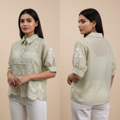 Woman wearing a light green blouse with lace details, shown from front and back on a beige background.