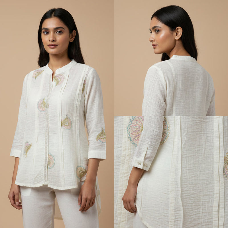 Woman wearing a white embroidered outfit on a beige background