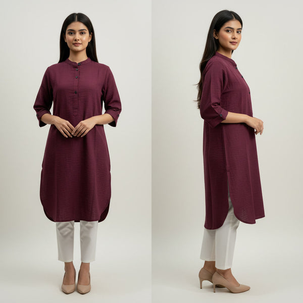 Woman wearing a maroon kurta with white pants on a plain background