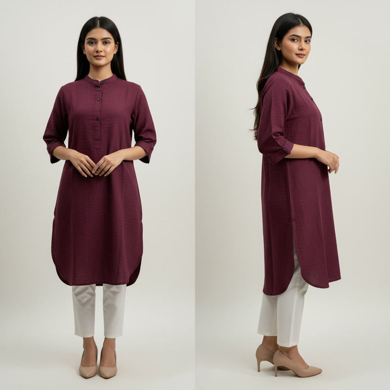 Woman wearing a maroon kurta with white pants on a plain background