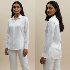 Woman wearing a white shirt and pants against a beige background