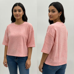 Woman wearing a pink textured shirt and blue jeans, shown from front and back on a white background