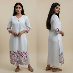 Woman wearing a white kurta with floral embroidery on a beige background