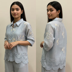 Woman wearing a light blue embroidered shirt and pants, shown from front and back.