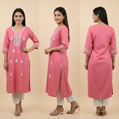 Pink kurta with white embroidery worn by a model on a beige background