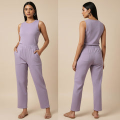Woman wearing a lavender jumpsuit on a beige background