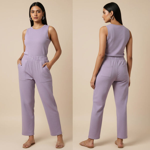 Woman wearing a lavender jumpsuit on a beige background