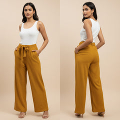 Woman wearing mustard yellow pants and a white top on a beige background