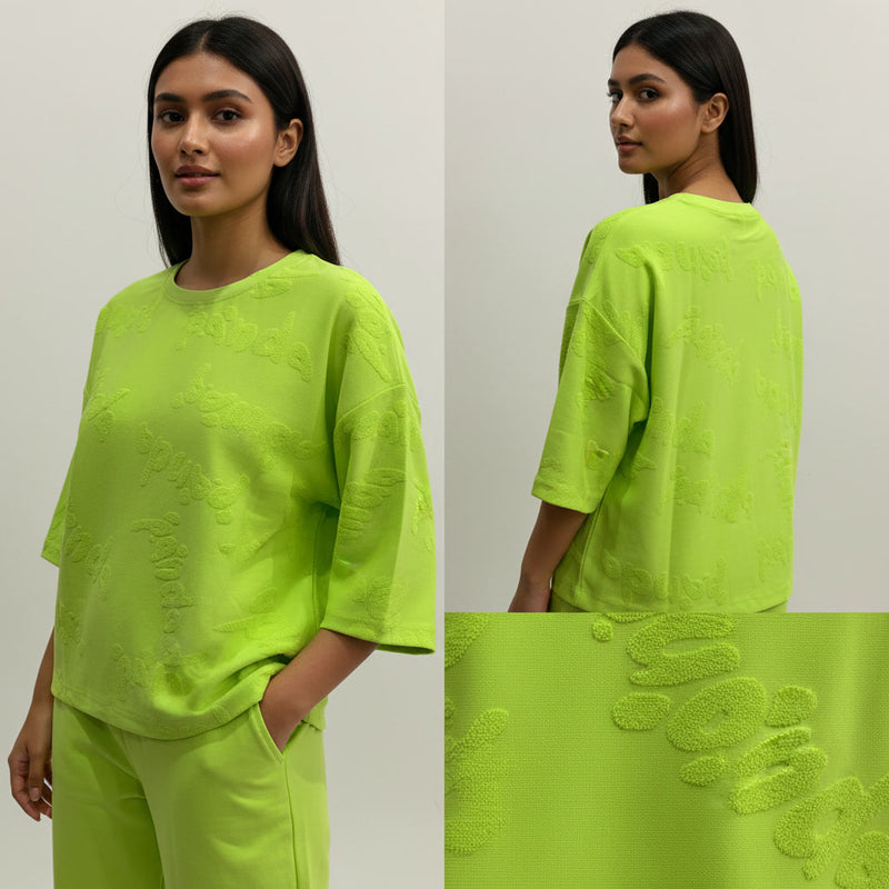 Woman wearing a bright green outfit with detailed fabric texture shown below.
