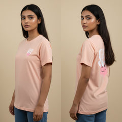 Woman wearing a pink t-shirt with a graphic design on a beige background