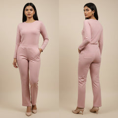 Woman wearing a pink ribbed outfit with long-sleeve top and pants on a beige background