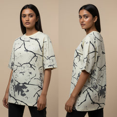 Woman wearing a white t-shirt with black abstract patterns on a beige background