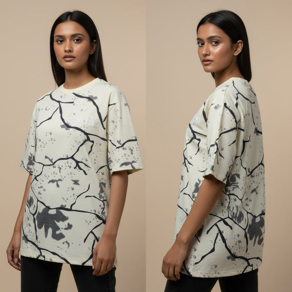 Woman wearing a white t-shirt with black abstract patterns on a beige background