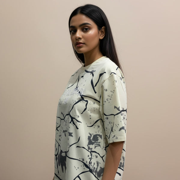 Woman wearing a white t-shirt with black abstract patterns on a beige background